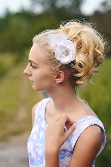 Female with updo wearing a white feathered hair flower